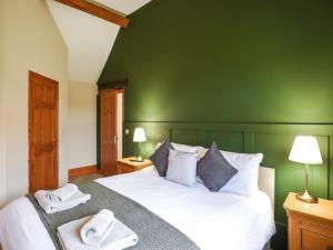 una camera verde con un letto e asciugamani di Uk46555 - Ragleth a Church Stretton Altre 9 foto