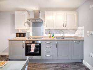 Una cocina con gabinetes blancos y un fregadero. en Apartment 1 The Boardwalk - Uk31781, en Great Yarmouth