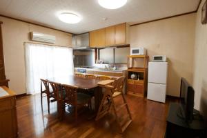 a kitchen with a table and chairs and a refrigerator at Cyclist inn Hachikakuno / Vacation STAY 78852 in Shimosato
