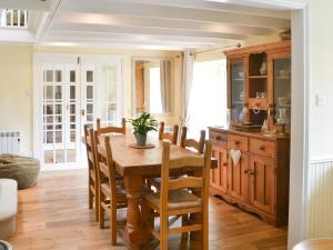 une salle à manger avec une table et des chaises en bois dans l'établissement Wisteria Cottage, à Alnham