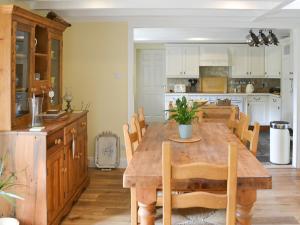 une cuisine et une salle à manger avec une table en bois dans l'établissement Wisteria Cottage, à Alnham