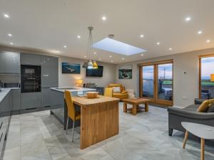 a kitchen and living room with a table and chairs at Ty Cwtch in Holyhead