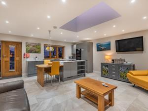 a kitchen and living room with a couch and a table at Ty Cwtch in Holyhead