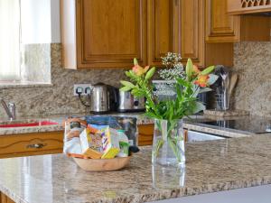 a vase of flowers sitting on a kitchen counter at Roslyn Cottage in Hamsterley