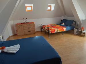 a bedroom with a bed and a dresser in a attic at Lou Castelou Pont d'Estaing in Sébrazac