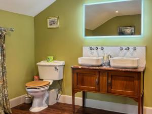a bathroom with two sinks and a toilet and a mirror at The West Wing in Doddington +2 photos