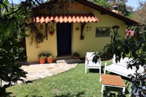 a house with two white chairs in a yard at Quinta de Carcavelos Agroturismo e Enoturismo in Celorico de Basto