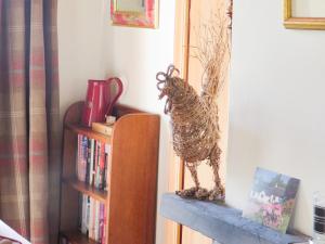 una statua di uccello seduta in cima a una libreria di Farragon Cottage a Foss