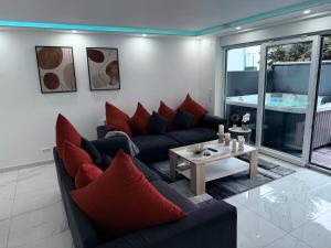 a living room with a couch and red pillows at Ferien- & Wellneswohnung mit privater Sauna und Whirlpool in Gelnhausen