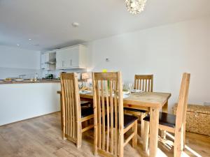 Una cocina y un comedor con mesa y sillas de madera. en 3 Harbour View, en Newquay