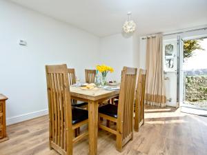 Un comedor con mesa y sillas de madera. en 3 Harbour View, en Newquay