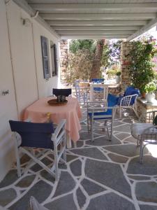 a patio with a table and chairs on a carpeted floor at kikis apartment a veranda dream in Drios
