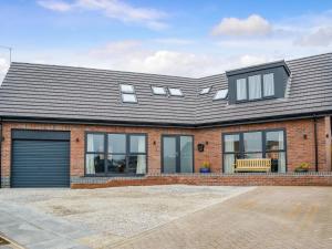 an extension to a brick house with windows at West Lodge in Sewerby