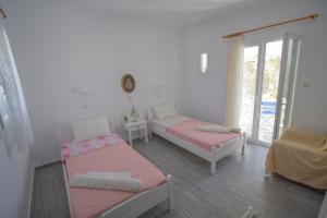 a bedroom with two beds and a window at kikis apartment a veranda dream in Drios