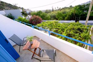 Un balcón con mesa y sillas y plantas. en Verano Studios, 