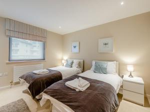 Un dormitorio con dos camas y una gran ventana. en Apartment 50, en Westward Ho 17 fotos más