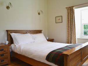 a bedroom with a bed with white sheets and a window at Westerton Lodge - Srrh in Crieff