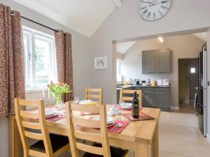 a kitchen and dining room with a table and a clock at Canal View in Ellesmere