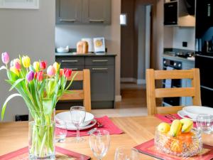 a dining room table with a vase of flowers on it at Canal View in Ellesmere +9 photos