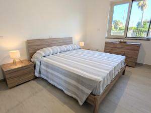 a bedroom with a large bed with two night stands at Riva di Davoli One Bedroom Apartment in Marina di Davoli