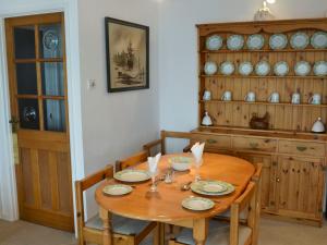 a dining room with a wooden table and chairs at Towan View in Newquay
