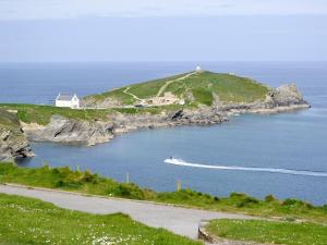 a boat in a body of water with a house at Towan View in Newquay +4 photos