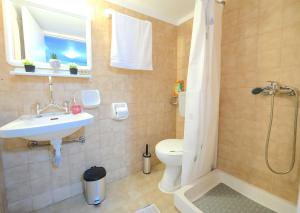 Un baño con lavabo, inodoro y ducha. en Verano Studios, 