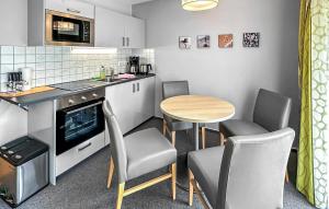 - une petite cuisine avec une table, des chaises et un comptoir dans l'établissement Ferienwohnung Trassenheide, à Trassenheide