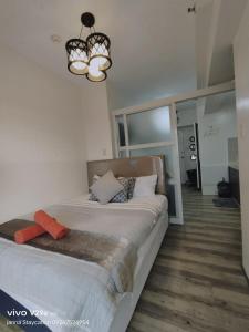 a bedroom with a bed and a chandelier at Home Escape Tagaytay by Janna 1919 in Tagaytay