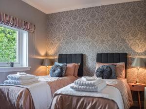 twee bedden naast elkaar in een kamer bij Dothan Farm Cottage in Cardenden