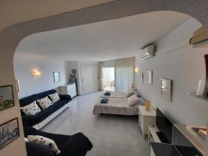 Una gran sala de estar con un sofá y una mesa. en Beach Front La Cala Penthouse studio Apartment, en La Cala de Mijas