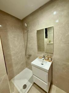 a white bathroom with a sink and a shower at Appartement T2- Ain zaghouen in Sidi Daoud