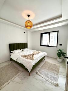 a bedroom with a large bed with a green headboard at Appartement T2- Ain zaghouen in Sidi Daoud