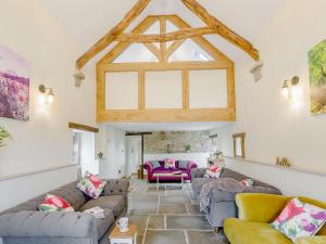 a living room with couches and a large window at Alton Hall Cottage in Ashover