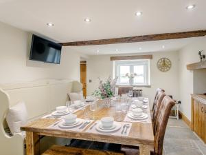 a dining room with a wooden table and chairs at Alton Hall Cottage in Ashover