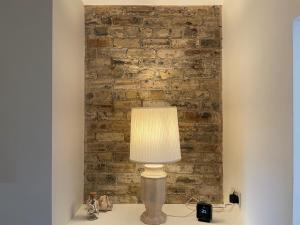 a lamp on a table in front of a brick wall at Harbour Walk in Amble