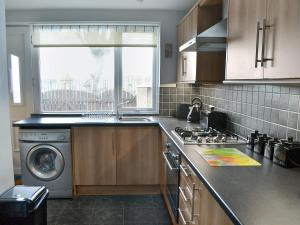 a kitchen with a sink and a stove and a window at Harbour Walk in Amble
