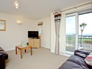 een woonkamer met een bank en een televisie bij 15 Belvedere Court in Paignton