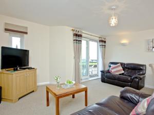 een woonkamer met een bank en een flatscreen-tv bij 15 Belvedere Court in Paignton