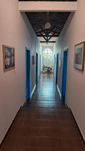 un corridoio con pareti blu e una vetrata di Hospedagem Aldeia Multiétnica a Alto Paraíso de Goiás