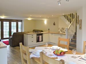 a kitchen and living room with a dining table and a kitchen and a dining room at Rhiwal Kitty - Uk6000 in Bodedern