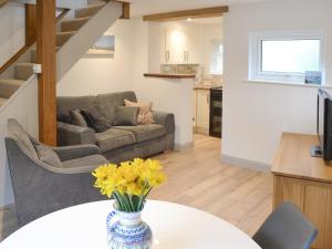 un salon avec un canapé et une table avec des fleurs dans l'établissement The Nest, à Uny Lelant