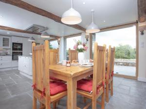 South TawtonにあるOrchard Barnの木製のテーブルと椅子のあるダイニングルーム
