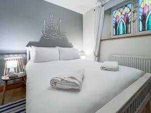 a bedroom with a large white bed with stained glass windows at The Rise in Scarborough +10 photos