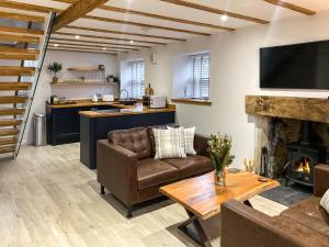 un soggiorno con divano e camino di Ivy Cottage a Falkland Altre 26 foto