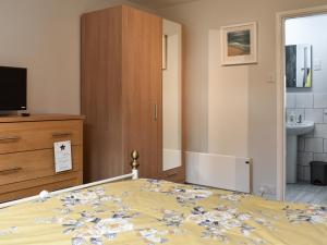a bedroom with a bed and a dresser at Old Orchard Cottage Near Eden in Luxulyan