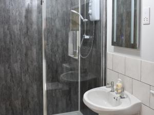 a bathroom with a shower and a sink at Old Orchard Cottage Near Eden in Luxulyan +4 photos
