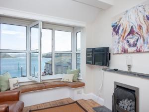 sala de estar con chimenea y ventana grande en The Lookout, en Salcombe