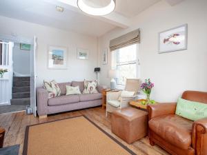 una sala de estar con un sofá y una silla en The Lookout, en Salcombe