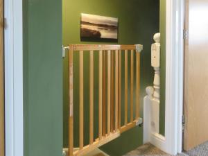 a staircase in a room with green walls at Cosy Cotswolds Townhouse in Honington